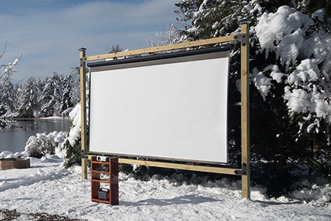 Timberline Cemented Screen Frame and Wireless Outdoor Movie Theater setup in front of a lake in the winter.